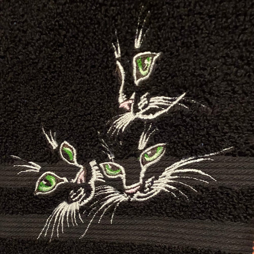 Embroidered design of a cat on a black fabric background
